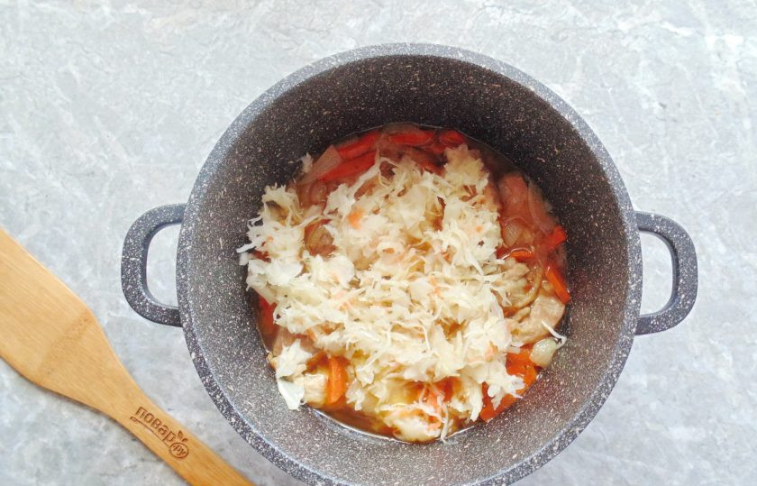 1. Этап. Мясо с капустой и яблоками: Квашеную капусту отожмите и добавьте в казан.