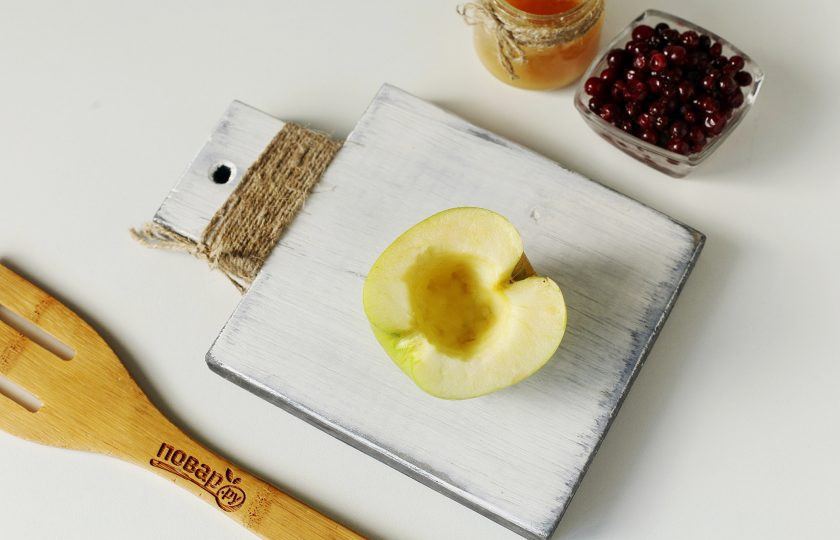 1. Этап. Запеченные яблоки с брусникой в духовке: Яблоки разрежьте на 2 части и извлеките середину.