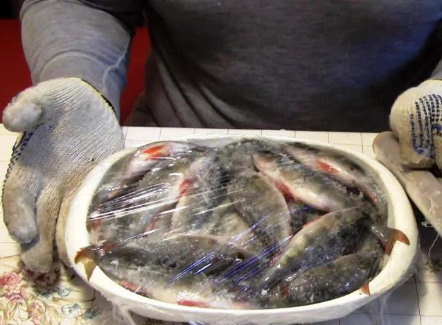 1. Этап. Окунь в коптильне: Рыбу обильно натрите солью, сложите в миску, накройте пищевой пленкой и уберите в холодильник на сутки.