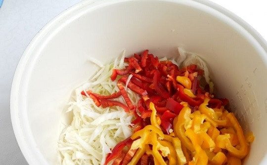 1. Этап. Салат Охотничий с капустой на зиму: 1. Овощи вымойте и обсушите. В чашу мультиварки (кастрюлю) отправьте нарезанный ломтиками перец и нашинкованную капусту.