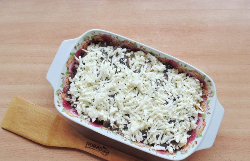 1. Этап. Сырная запеканка: Рассольный сыр натрите на терке и выложите поверх грибов с луком.