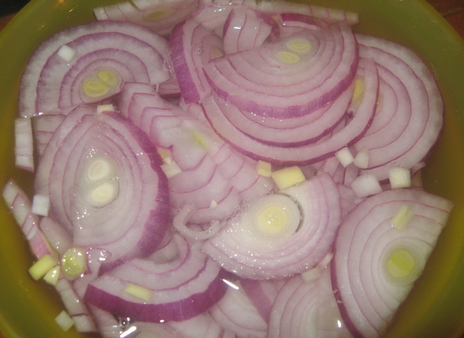 1. Этап. Салат Санта Клаус: Очищенный лук нарежьте полукольцами. Выложите их в миску и залейте уксусом на 15 минут.