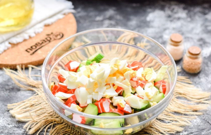 1. Этап. Крабовый салат с чукой: Вареное яйцо почистите и нарежьте кубиками, добавьте в салат. Заправьте все ложкой масла, добавьте соль и перец по вкусу.