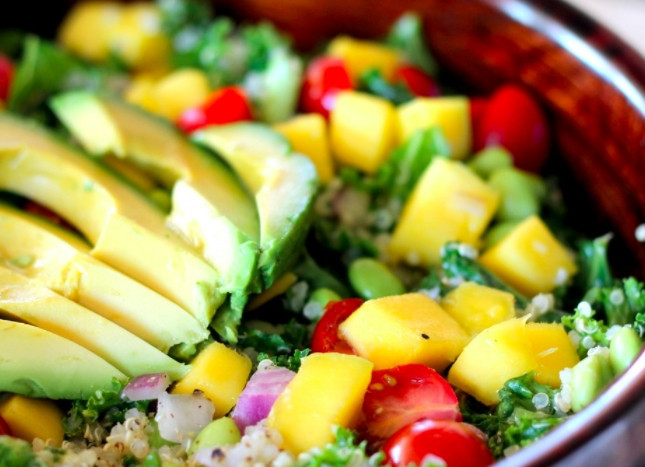 1. Этап. Салат в пост: В салатницу выложите кале, порванную руками на кусочки. Помидоры, лук и манго смешайте с киноа и заправкой, выложите на капусту. Авокадо очистите и нарежьте дольками, выложите на салат.