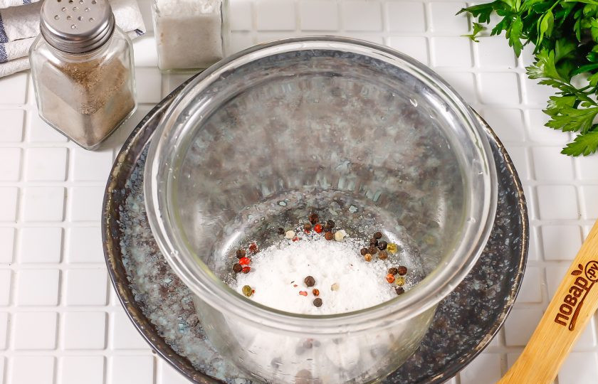 1. Этап. Пузанина в рассоле с чесноком: В глубокую стеклянную емкость всыпьте соль и горошины черного перца. Соль обязательно должна быть крупного помола, не йодированная.