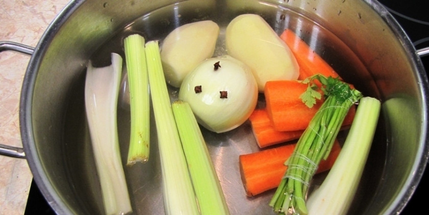 1. Этап. Уха из головы сазана: В кастрюлю мы заливаем 2 литра воды и в нее перекладываем 2 целые картофелины, головку лука с гвоздикой, нарезанную морковь и стебли сельдерея и стебли петрушки. Варим бульон в течение 30 минут.
