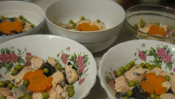 1. Этап. Заливное из сома: Как только вода закипит, достаньте лавровый лист. Иначе бульон будет горьким. Поварите на медленном огне ещё 2-2,5 часа. Затем достаньте всё из бульона, отставьте его в сторону, чтобы остыл. Сома разберите на мясо и кости. Кости выбрасываем. Морковь нарежьте, она будет в холодце. Выложите в мисочки для холодца мясо сома, морковь и зелёный горошек. Желатин разведите в воде, добавьте в бульон и немного поварите до полного растворения желатина. Залейте формочки.