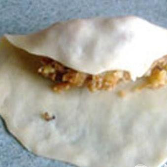 1. Этап. Вареники-Крученики постные: 1. В первую очередь приготовим тесто. В миске смешиваем соль и муку, две ложки растительного масла вливаем в кипяток, и завариваем этим кипятком муку. Достаточно энергично размешиваем, сформируем шар и затем кладем его в целлофановый кулек. Оставляем до остывания. Затем размером с грецкий орех отрываем шарики от теста, и каждый из них раскатываем.