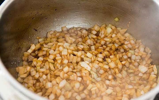 1. Этап. Тушеная баранина с овощами: 4. Измельчите лук кубиками, отправьте его в масло с соком от мяса. Обжарьте на среднем огне, помешивая.