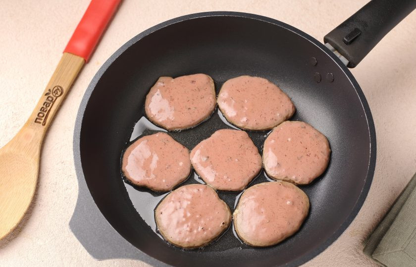 1. Этап. Оладьи из куриной печени: Разогрейте сковороду с маслом. Выкладывайте печёночное тесто при помощи столовой ложки, формируя небольшие оладушки.