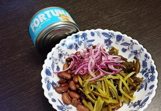 1. Этап. Салат из фасоли с тунцом: Маринованный огурец нарезать соломкой и добавить к фасоли. Туда же выложить маринованный лук. Тунца я положу в салат позже. Мне не очень нравится, когда при перемешивании он расползается на волокна. Лучше, когда тунец кусочками. Я возьму консервированного тунца FORTUNA.