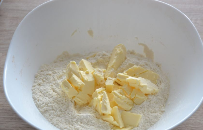 1. Этап. Киш с копченой курицей: В миску для замешивания теста всыпьте муку, добавьте порезанное на кусочки охлажденное сливочное масло, щепотку соли и разрыхлитель для теста.