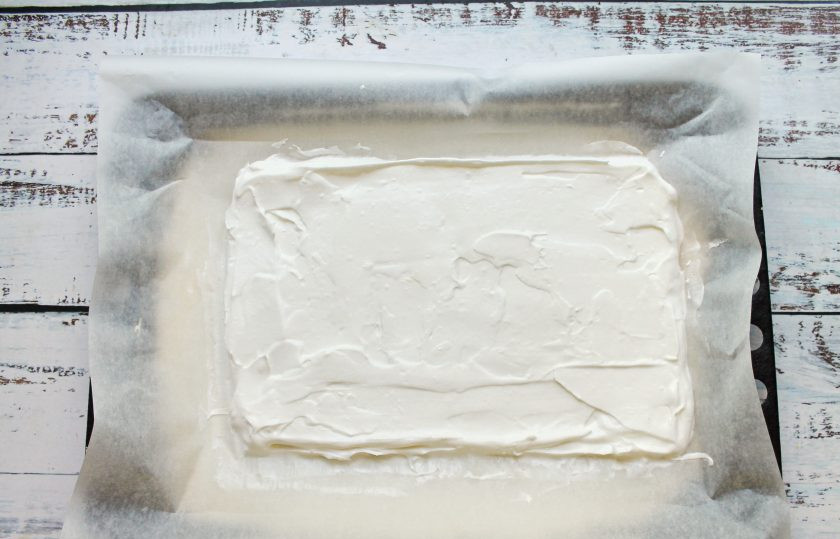 1. Этап. Меренговый рулет с мандаринами: Противень застелите пергаментом и выложите белковую массу, разровняйте в прямоугольник 40 на 35 сантиметров.