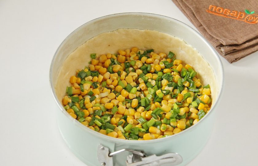 1. Этап. Французский пирог с кукурузой и помидорами: 7. Соедините кукурузу, предварительно слив с нее жидкость, и нарезанный зеленый лук. Добавьте немного соли, перец по желанию, перемешайте и выложите равномерно на тесто.