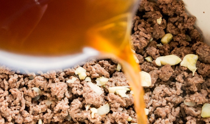 1. Этап. Гуляш из говядины с сыром: 1. Для начала немного обжарьте фарш с солью в глубокой кастрюле с толстым дном. Затем добавьте оба соуса, чеснок пластинками. Влейте бульон.