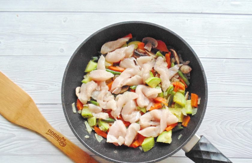 1. Этап. Куриное филе с овощами на сковороде: Куриное филе помойте, нарежьте небольшими кусочками и выложите к овощам. Посолите, поперчите.