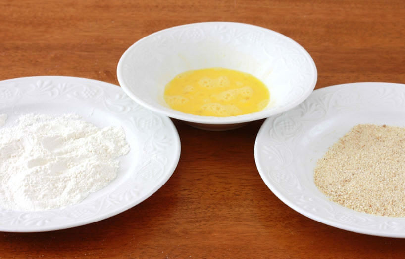 1. Этап. Шницель свиной: Приготовьте 3 отдельных миски для панировки: со взбитыми яйцами, сухарями и мукой.
