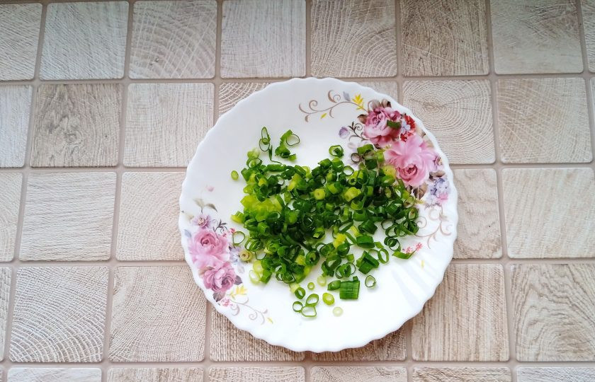1. Этап. Слоёный салат с ананасами, курицей и жареными грибами: Зелёный лук вымойте и нарежьте мелкими колечками.