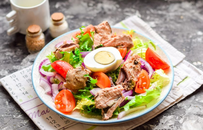 1. Этап. Салат с тунцом и черри: Добавьте в салат половину куриного яйца, посолите и поперчите по вкусу. Сбрызните маслом и соком лимона.