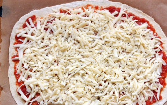 1. Этап. Пицца на противне: 3. Выложите на тесто томатный соус и распределите его по всему тесту, оставьте по 1,5 сантиметра от края. Поверх соуса выложите сыр и добавьте черный молотый перец.