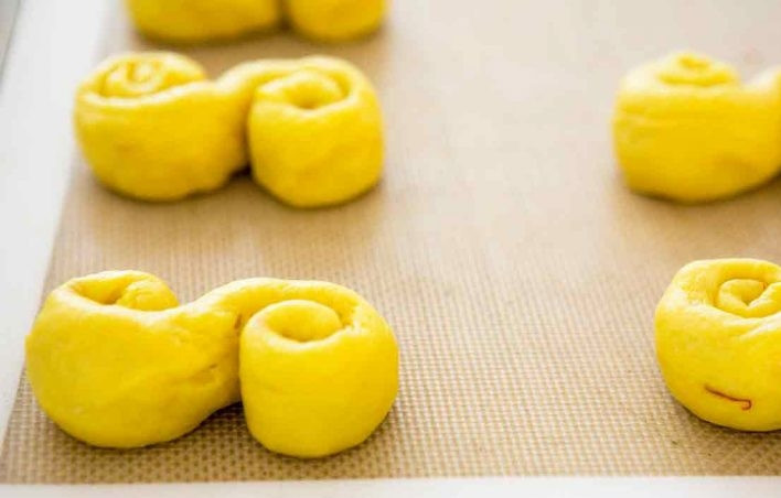 1. Этап. Булочки с шафраном: 11. Выложите всю выпечку на противень и застелите полотенцем или пленкой.