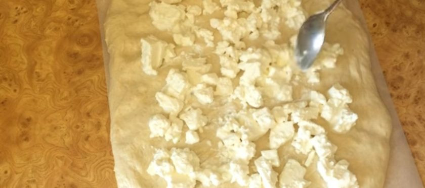 1. Этап. Чамбелла с брынзой и специями: 4. Выложите тесто на пергамент и руками растяните его в равный прямоугольник толщиной 1 см. Выложите нарезанную на средние кусочки брынзу и специи по вкусу. Сверните прямоугольник в рулет, затем сформируйте бублик и закрепите концы.