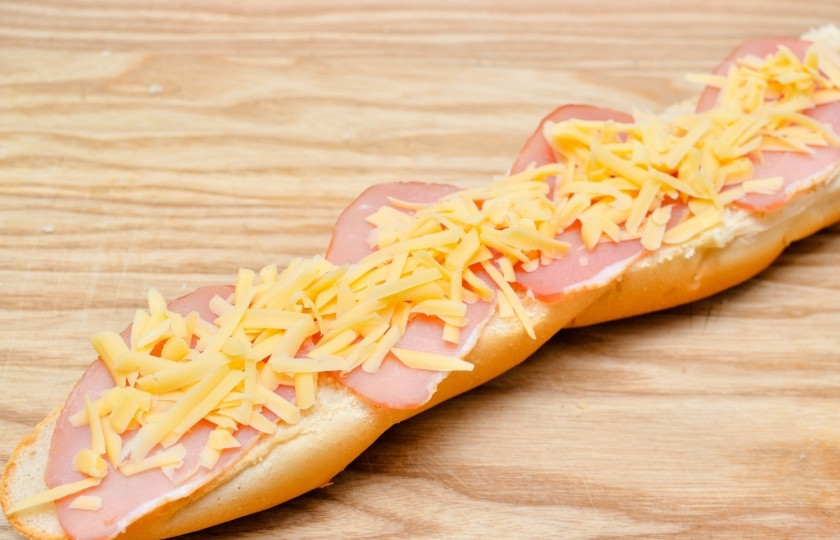 1. Этап. Cэндвич как в Сабвей: Разрежьте багет напополам вдоль. На одну сторону, желательно верхнюю, выложите ломтики ветчины и натрите сверху сыр. Поставьте в духовку буквально на пять минут, чтобы сыр расплавился.