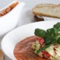 Гаспачо с крабами и авокадо Подготовить продукты. Вымыть и обсушить зелень и овощи. Закипятить воду для ошпаривания помидоров. Нарезать стебель сельдерея и зубчик чеснока. У помидоров сверху надрезать кожицу крест-накрест. Опустить помидоры в кипяток на 30 секунд или пока не полопается кожица. Извлечь шумовкой, остудить. Снять с помидоров кожицу, нарезать их на дольки и выбрать семена. Для гаспачо потребуется только мякоть. Подготовленные таким образом помидоры поместить в блендер, добавить сельдерей и чеснок, добавить соль и перец по вкусу (табаско и ворчестер по желанию). Хорошо взбить, добавить столовую ложку масла и еще раз взбить. (Чтобы сделать гаспачо более жидким - добавить лед или воду.) Полученный суп выправить на соль и перец, перелить в соусник/кувшин и поставить в холодильник охлаждаться. Тем временем приготовить салат. Для салата можно использовать как помидоры конкасе (без семян и шкурок, нарезанные кубиками), так и четвертинки черри. Черри разрезать и выложить на бумажное полотенце слегка стечь. Нарезать авокадо и крабовые палочки на кубики приблизительно одинаковых размеров. * Крабовые палочки своим сладковатым вкусом здесь уравновешивают остроту гаспачо. Если вы хотите добиться большего сходства с крабами по консистенции, их нужно натереть на мелкой терке. Замешать в миске салат, заправив его оливковым маслом, лимонным соком, солью и перцем по вкусу. С помощью сервировочного кольца выложить салат в середину тарелки и украсить сверху зеленью. В таком виде салат подается на стол вместе с охлажденным супом. После чего, суп выливается в тарелку вокруг салата и уже по желанию самостоятельно посыпается солью/перцем/ сбрызгивается оливковым маслом.