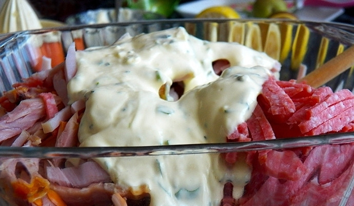 1. Этап. Салат Новогоднее настроение: Переложите подготовленные овощи и мясную нарезку в салатник, в котором будете подавать блюдо. Достаньте из холодильника заправку, добавьте её к остальным ингредиентам. Тщательно перемешайте и посолите по вкусу. Не забудьте, что мясо и маринованные огурцы уже содержат соль, поэтому не переборщите с ней. Подавайте блюдо к столу порционно или в общем салатнике.