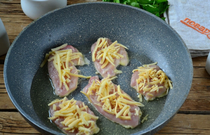 1. Этап. Куриные отбивные в сырном кляре: Сверху на каждую отбивную положите немного сыра.