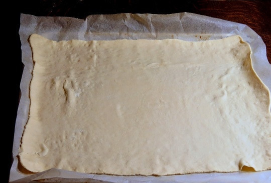 1. Этап. Выпечка из слоеного теста в духовке: 3. Духовку разогрейте до 180-190 градусов. Тесто выложите в форму, застелив ее пергаментом или смазав маслом.