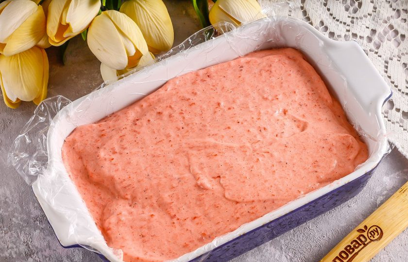 1. Этап. Маршмеллоу из клубники: Застелите глубокую емкость пищевой пленкой и обязательно смажьте ее ратсительным маслом, иначе вы потом не сможете снять ее с ягодного мусса. Влейте взбитую массу и аккуратно разровняйте по всей поверхности. Поместите в холодильник на 2-3 часа, а лучше — в морозильную камеру на 40-50 минут.