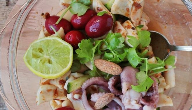 1. Этап. Салат из кальмара с огурцом: Положите в салатник обжаренные кальмары и консервированные осьминоги, а также нарезанные огурцы. Откройте банку оливок, слейте воду и переложите оливки в салатник. Добавьте зелень сельдерея, заправьте оливковым маслом и соком лайма. Посолите и перемешайте.