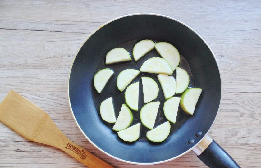 1. Этап. Салат из кабачков с редиской: Кабачок вымойте, нарежьте на половинки кружков. Выложите в сковороду.