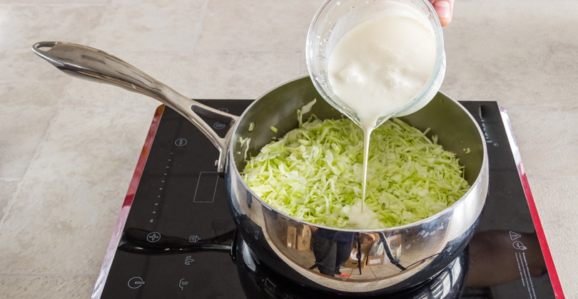 1. Этап. Капустный пирог на сметане и сливках: 1. Вымойте и нашинкуйте капусту очень тонко, затем разрежьте на несколько частей. Выложите капусту в сотейник или в сковороду. Отправьте ее на огонь, добавьте сливки и соль, тушите после закипания на слабом огне 15-20 минут.