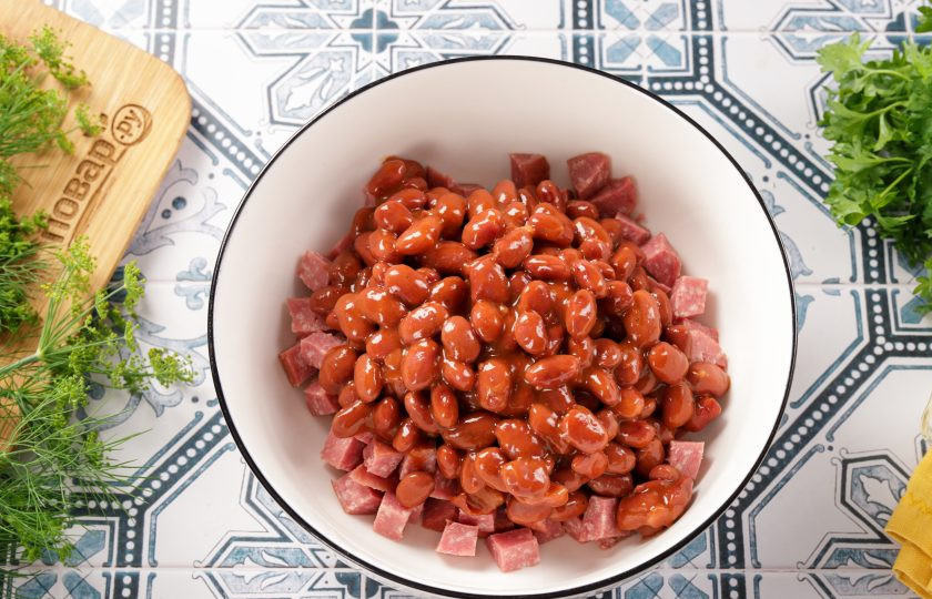 1. Этап. Салат с фасолью, морковью и колбасой: Добавьте фасоль, предварительно откинутую на сито, чтобы убрать жидкость.