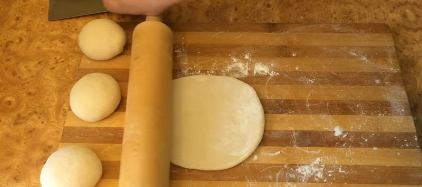 1. Этап. Лаваш из постного теста: 2. Придайте тесту форму колобка, накройте и оставьте под пленкой на 20 минут. Разделите тесто на 4 части и раскатайте каждую из них в тонкий круглый пласт диаметром 20-25 см. Раскатывайте одним движением, каждый раз переворачивая лепешку.