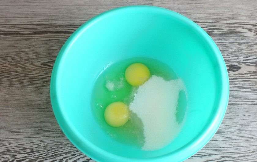 1. Этап. Ленивая ватрушка с творогом: Приготовьте тесто для ватрушки. Смешайте в чаше 2 яйца, 100 грамм сахара, ванилин и щепотку соли.