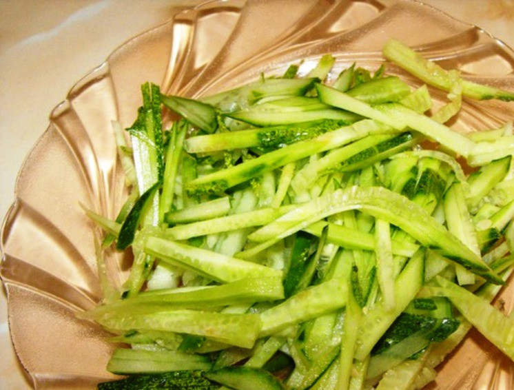 1. Этап. Салат из кальмаров с овощами: Огурцы натрите на терке для корейской моркови.