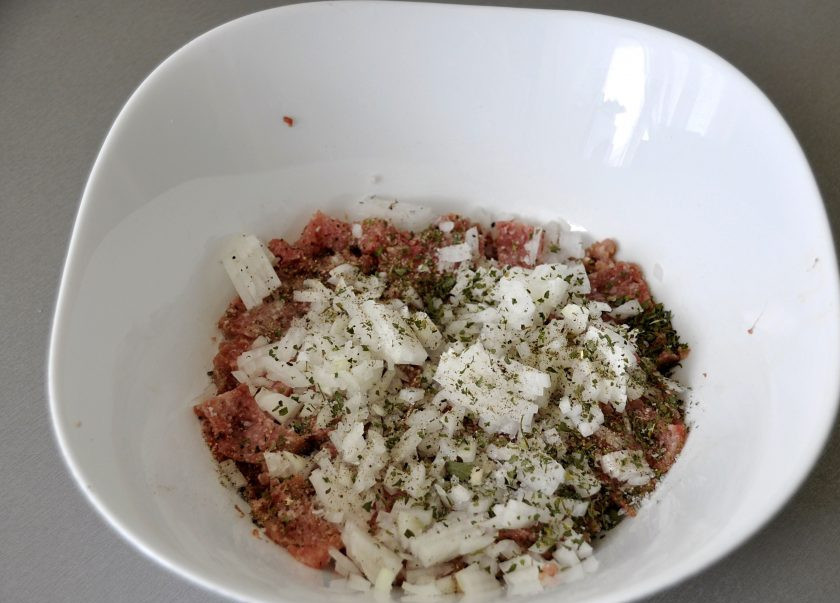 1. Этап. Кавказские чебуреки: Заправьте фарш мелко нарезанным луком, кавказскими травами, посолите и поперчите по вкусу.