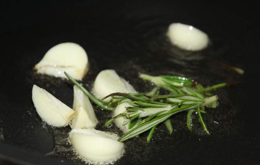 1. Этап. Жареный картофель с розмарином: Чеснок порежьте дольками и бросьте на сковороду вместе с розмарином.