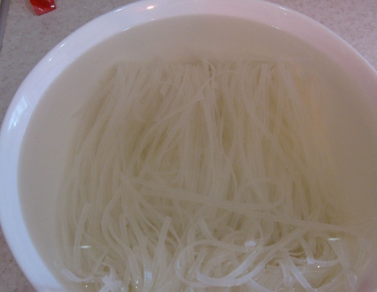 1. Этап. Китайская лапша с морепродуктами: 2. Китайскую рисовую лапшу достаю из упаковки и перекладываю в тарелку, заливаю холодной водой и оставляю на 10 минут.