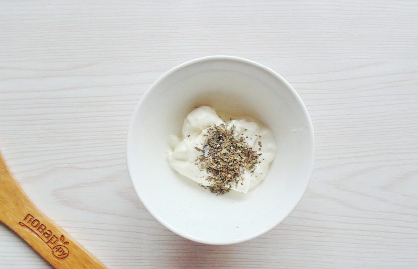1. Этап. Запеканка с куриными ножками: В мисочку выложите сметану, половину чайной ложки сушеного базилика, соль и перец, перемешайте.