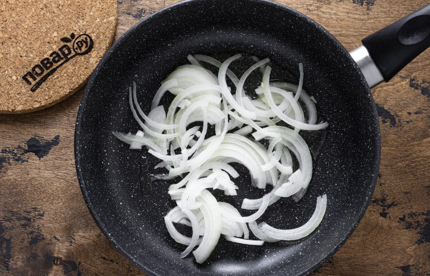 1. Этап. Салат Бакинский с баклажанами: Репчатый лук нарежьте полукольцами и обжарьте в сковороде до мягкости и золотистого цвета.