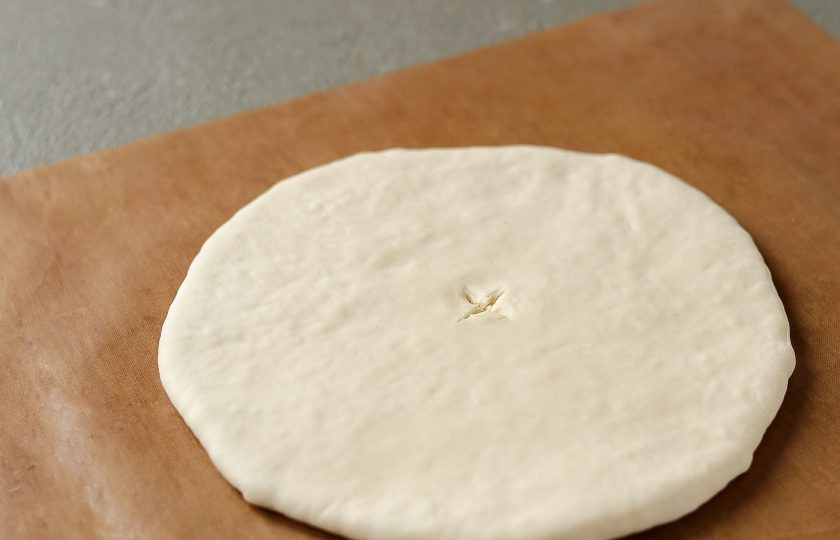 1. Этап. Постные хачапури: Раскатайте лепешку. В центре сделайте отверстие.