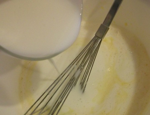 1. Этап. Оладьи из прокисшего молока: Понемногу вливайте в яичную массу прокисшее молоко, не переставая помешивать. Размешайте ингредиенты так, чтобы их консистенция была однородной.