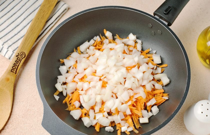 1. Этап. Суп на завтрак: Пока варится картофель, разогрейте сковороду с маслом и выложите нарезанный кубиками лук и тёртую морковь.