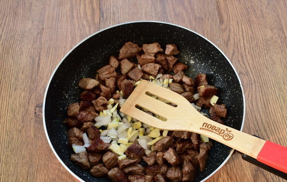 1. Этап. Стифадо из говядины с рисом: Говядину нарежьте на кусочки, по 3 см. На оставшемся разогретом масле обжарьте кусочки говядины до румяной корочки. Добавьте измельченные лук и чеснок.