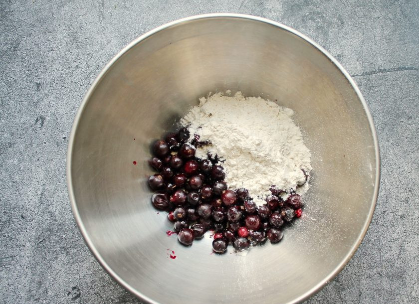 1. Этап. Шотландский новогодний кекс: Черную смородину разморозьте на сите и дайте стечь соку. Переложите ягоды в миску и добавьте муку, специи и потрясите, чтобы они полностью покрылись.