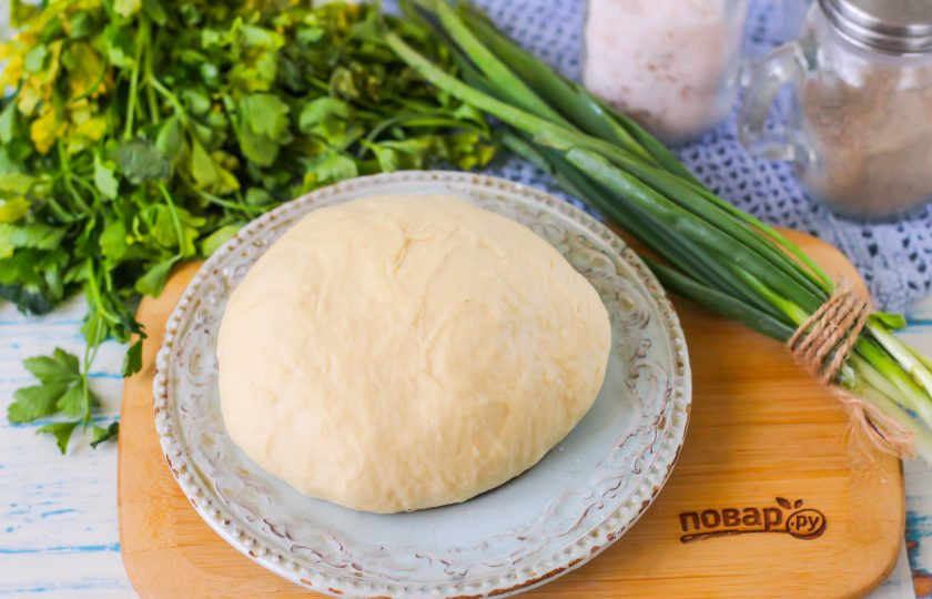 1. Этап. Тесто для пельменей по ГОСТу: Замесите рукой плотное тесто, отсыпав часть муки для раскатки на стол. Первое время тесто будет липнуть к рукам, поэтому почаще обмакивайте их в муку. Спустя 3-4 минуты просто сформируйте из теста колобок.